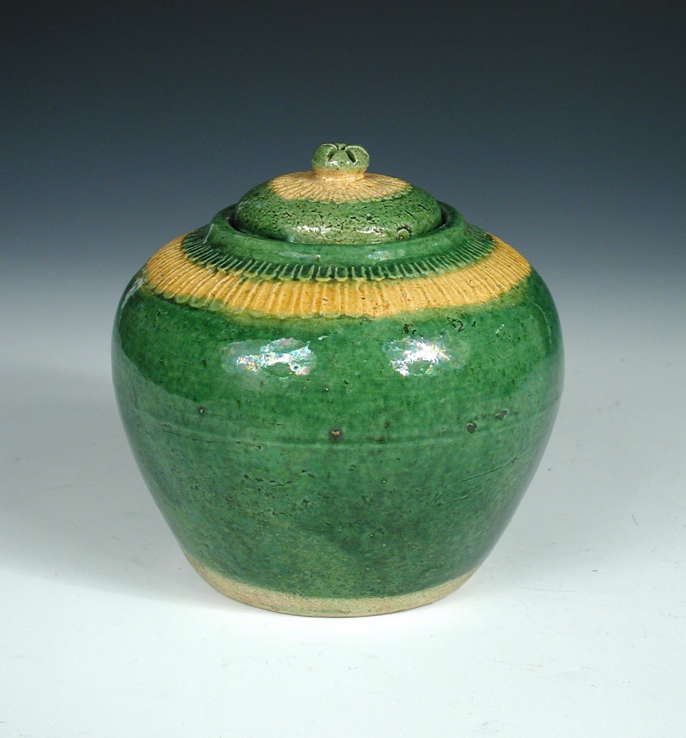 A Liao green glazed jar and cover, the shoulders moulded with two petal bands one coloured ochre and