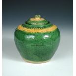 A Liao green glazed jar and cover, the shoulders moulded with two petal bands one coloured ochre and
