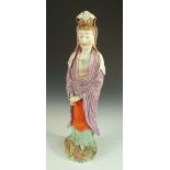 A later coloured 18th century blanc de Chine figure of Guanyin, she stands on a cloud scroll base