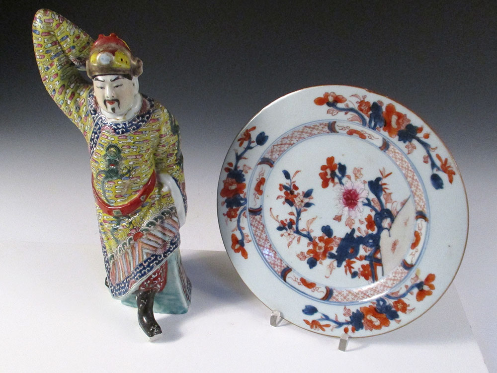 A 20th century figure of a man and an 18th century plate, the man stepping forward with right arm