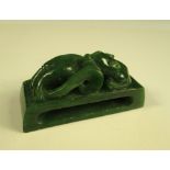 A Qing spinach green jade sheath ring, the rectangular shape pierced and carved with a reclining