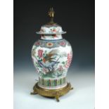 A 19th century famille rose covered jar ormolu mounted as a lamp painted with an exotic bird perched