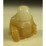 A Qing nephrite jade Budai pendant, the bare chested monk seated with his bag of possessions in