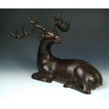 A lacquered wood reclining deer, its five point antlers removable from its head turned to look