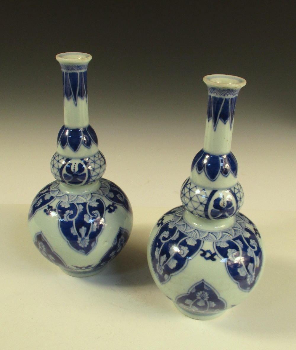 A pair of Kangxi style blue and white double gourd vases, the cylindrical necks with flared rims