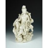 A 20th century blanc de chine figure of Guanyin seating on a lotus leaf throne, her left foot