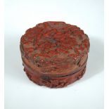 A 19th century cinnabar lacquer cylindrical box and cover, the exterior moulded in relief with