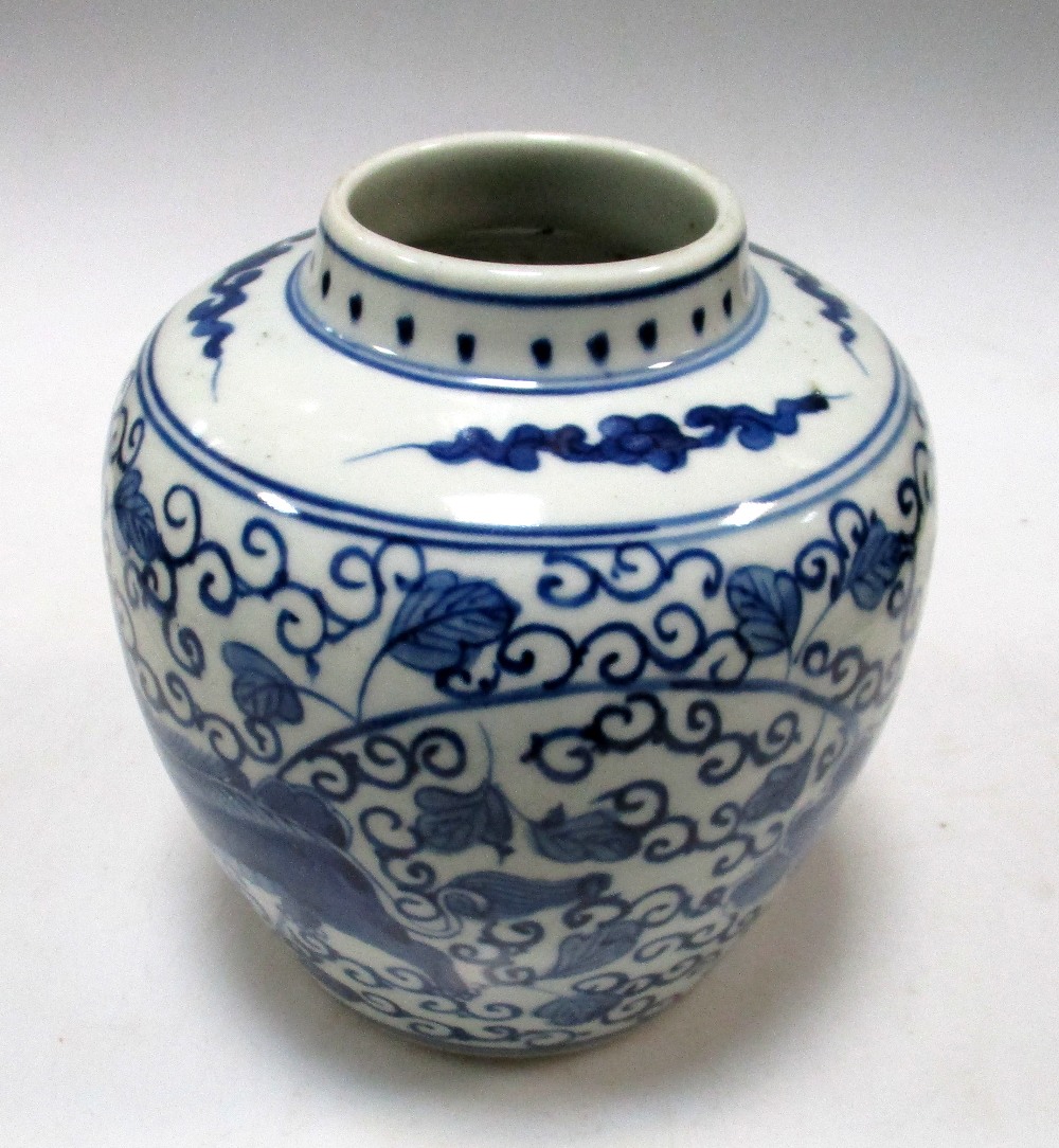 A Transitional style blue and white jar, painted with two Buddhist lions running against flowering
