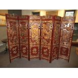 A 19th century Chinese parcel gilt and carved hard wood 6-fold screen, each panel with relief panels