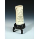 A late 19th/early 20th century carved and lacquered ivory brush pot, one side with a relief