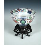 A wucai bowl, six character mark of Wanli, with a wood stand, the exterior painted with flower heads