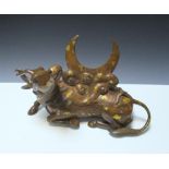 A gold splashed bronze qilin, the single horned reclining animal looking up towards the crescent