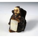A 19th century lacquered wood figure of a sage, his hirsute head of ivory, a mother of pearl