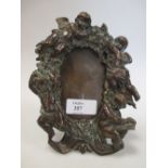 A copper early 20th century photograph frame, decorated with cherubs