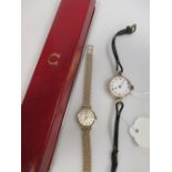 An Omega gold lady's wristwatch, in case together with an earlier gold wristwatch (2)