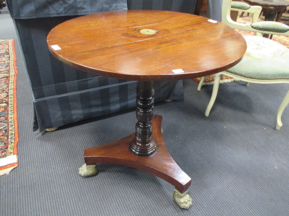 A mahogany wine table with drop flat top, turned column on brass paw feet, 67 x 63cm