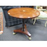 A mahogany wine table with drop flat top, turned column on brass paw feet, 67 x 63cm