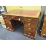 An Edwardian oak red leather topped pedestal writing table, 130cm wide