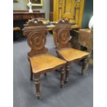 A pair of Edwardian mahogany hall chairs