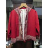 An Indian red wool child's jacket embroidered with metal thread and silk lined