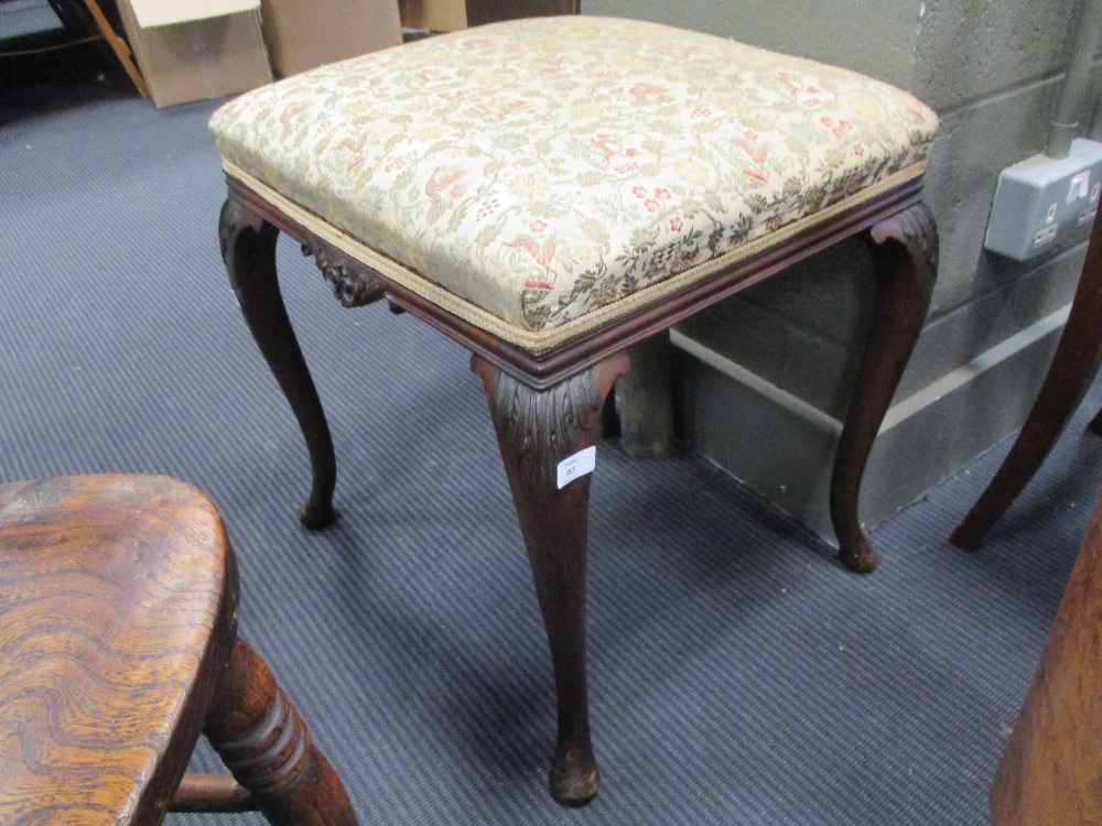 A late Victorian mahogany stool with leaf carved cabriole legs