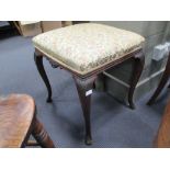 A late Victorian mahogany stool with leaf carved cabriole legs