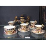 Four Derby Imari cups and saucers and sugar bowl, and a blue and gilt Derby urn shaped vase and