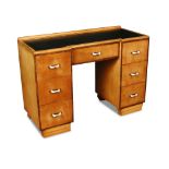 An Art Deco satin birch desk, the leather inset top with breakfront outline above a central frieze