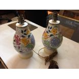 A pair of Poole Pottery table lamp bases, the baluster forms painted with flowers and foliage,