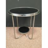 An Art Deco chrome occasional table, the black circular top on four shaped tubular supports united