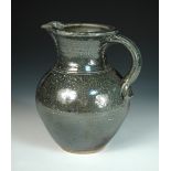 § Michael Casson (British, 1925-2003) a salt glazed jug, with incised wave decoration, impressed