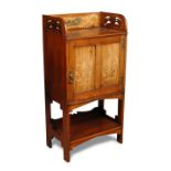 An Art Nouveau mahogany side cabinet, the galleried top with pierced sides, the back inlaid and