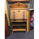 An Art Nouveau oak student's bureau, the galleried top pierced with bat and crescent moon, the