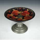 A Moorcroft Pomegranate pattern tazza, the circular dish raised on a repoussé decorated pewter