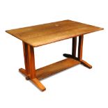 A Cotswold School walnut refectory table, the rectangular top raised on twin square columns to