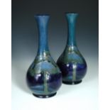 A composed pair of Moorcroft Moonlit Blue pattern bottle vases, each with slender neck to a