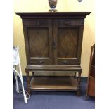 A Continental oak cabinet on stand, the pair of panel doors with ebony strung lozenge inlay and