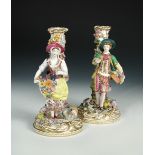 A pair of 19th century Minton figural candelsticks, modelled as a gallant and companion, in 18th
