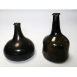 Two early 18th century globe and shaft green glass bottles, both with trailed rims to the necks, the