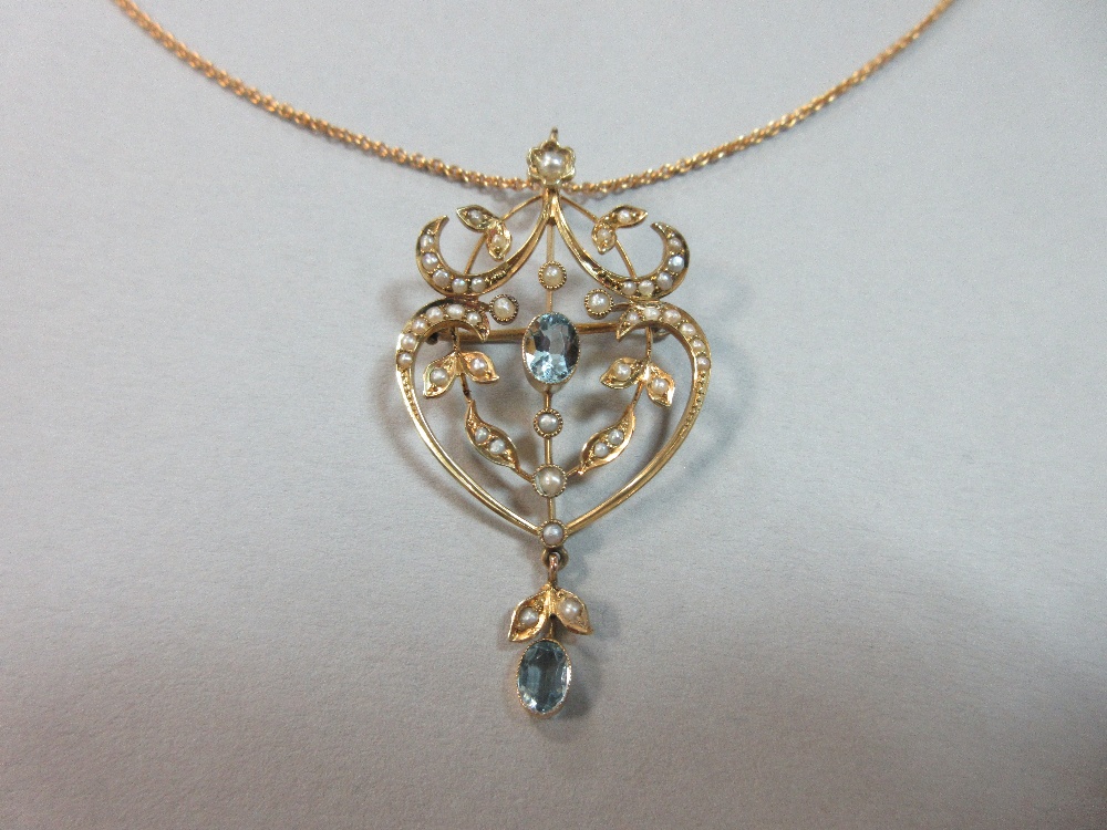An Edwardian aquamarine and seed pearl pendant / brooch on an 18ct gold chain, of light, pierced and - Image 2 of 4