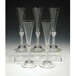 A set of five 18th century air twist champagne flutes, each with tall trumpet bowl above a bun