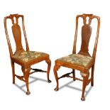 A pair of George I elm high back chairs, with needlepoint drop-in seats, on stretchered cabriole