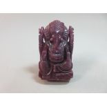 A carved ruby figure of Ganesh, the opaque purplish stone weighing 454cts, carved in deep relief