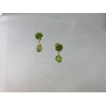 A pair of peridot eardrops, each post headed by a claw set round cut peridot and suspending