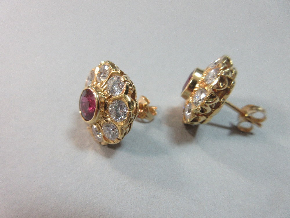 A pair of rhodolite and diamond flowerhead earstuds, each round cut rhodolite garnet collet set in a - Image 3 of 7
