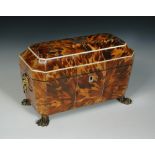 A Regency tortoiseshell tea caddy, the sarcophagus form with lion mask handles and raised on paw