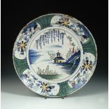 An 18th century Dutch Delft polychrome charger, decorated in the Chinoiserie manner with a house,