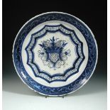 An 18th century Delft blue and white charger, decorated to the centre with a shield, within blue