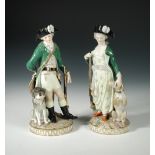 A pair of late 19th/early 20th century Meissen figures of hunters, the green jacketed lady and