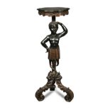 A Blackamoor torchere, late 19th century, carved with a standing figure on three large scroll carved